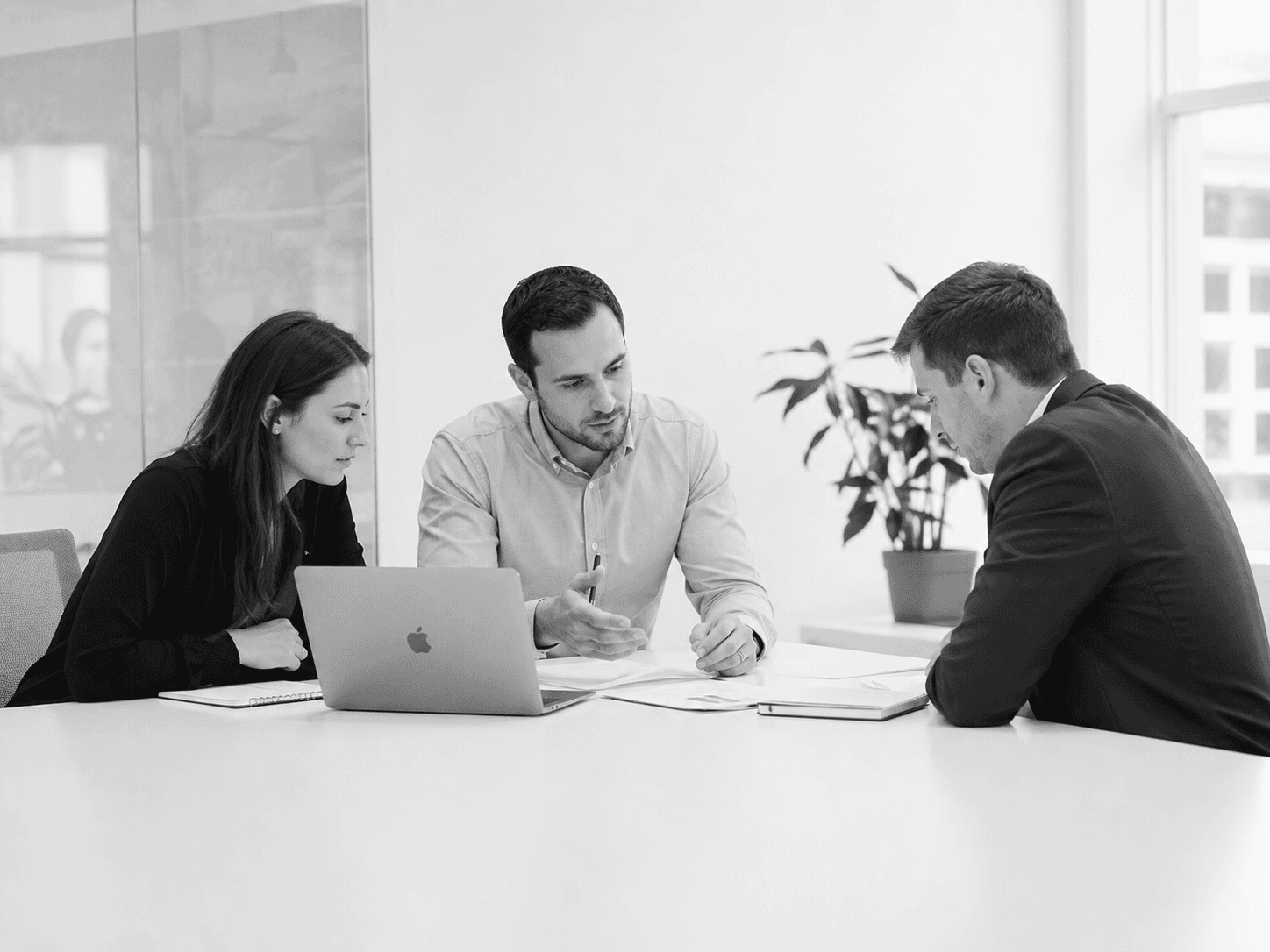 Consultants working through a business problem in a bright boardroom